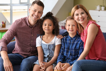 Happy couple with little adopted children at home