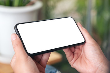 Mockup image of hands holding black mobile phone with blank screen