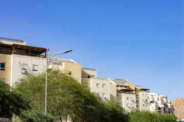 Fototapeta premium common city street with small living houses and green trees perspective view in bright clear weather time 