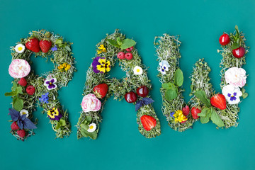 Top view of a inscription a raw from fresh microgreens plants of a diverse flowers and berrys, on a green background.