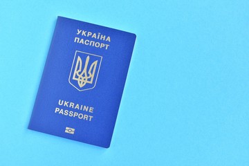Biomedical Ukraine id passport on bright blue background with selective focus and empty space for photo or text. Ukrainian id passport with a golden symbol trident on blue backdrop. Copy space 