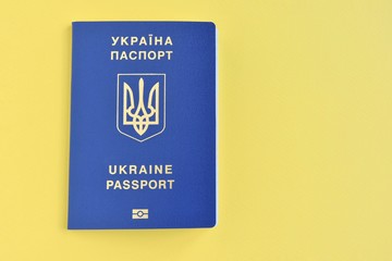 Ukrainian id passport with a golden symbol trident on yellow backdrop. Biomedical Ukraine id passports on yellow background with selective focus and empty space for photo or text. Copy space 