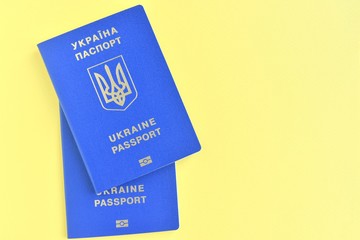 Two Ukrainian id passport with a golden symbol trident on yellow backdrop. Biomedical Ukraine id passports on yellow background with selective focus and empty space for photo or text. Copy space 