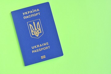 Biomedical Ukraine id passport on bright green background with selective focus and empty space for photo or text. Ukrainian id passport with a golden symbol trident on neon backdrop. Copy space 