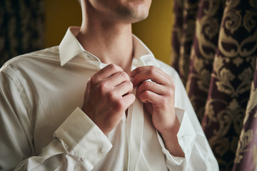 businessman dresses white shirt, male hands closeup,groom getting ready in the morning before...