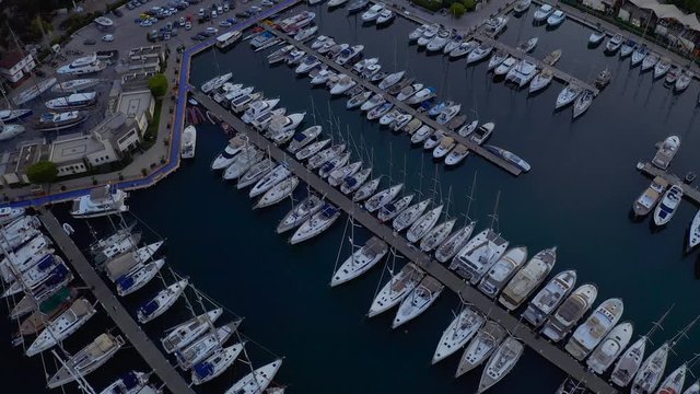 Fly over an elite yachts moored in the port eary in the morning. View from above 4k