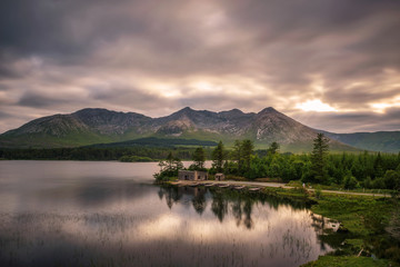 Lough Inagh in Ireland with a cabin and boats at the lake shore