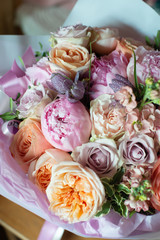 peonies in a bouquet of flowers on a leg in the interior of the restaurant for a celebration shop floristry wedding salon