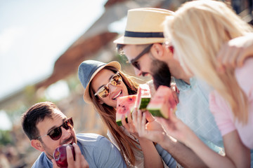 Friends eating watermelons on the beach