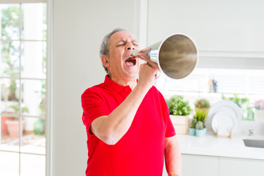 Senior man shouthing excited through vintage metal megaphone