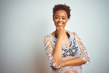 Young african american woman with afro hair wearing a bikini over white isolated background looking confident at the camera smiling with crossed arms and hand raised on chin. Thinking positive.