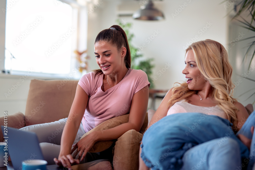 Canvas Prints Female friends using laptop at home