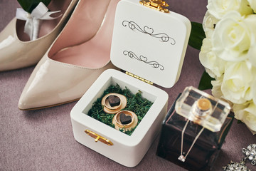 bridal accessories such as shoes, bouquet , ring and perfume lie on a table