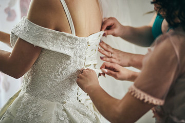 Morning of the bride when she wears a beautiful dress, woman getting ready before wedding ceremony