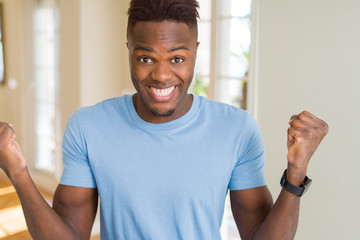 Handsome african american man wearing casual t-shirt celebrating surprised and amazed for success with arms raised and open eyes. Winner concept.