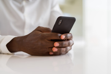 Close up of african man hands using smarpthone