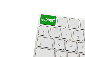 green support key in the corner of white wireless computer keyboard, isolated on the white. psychological and material support for people in difficult life situations - concept