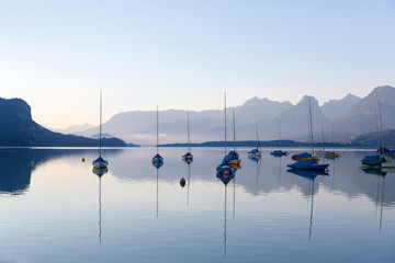 Beautiful scenery during sunrise of Lake Wolfgangsee in Austrian Alps with the sailboats parked on the waterfront. 