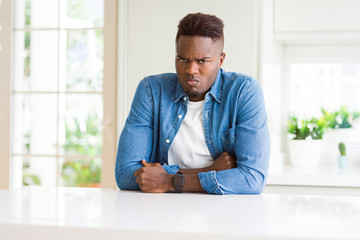 Handsome african american man at home skeptic and nervous, disapproving expression on face with crossed arms. Negative person.