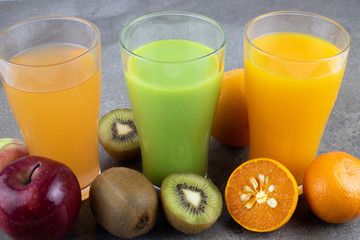 Juices of apple, kiwi orange in a glass.