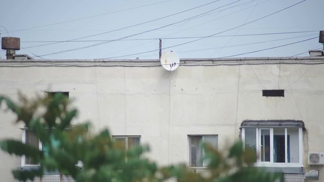Satellite dish on the wall of a multistory building
