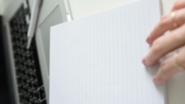 Zoom in on Work table with green plant in grey pot, female hands open a notebook with an inscription Today is yor day! Laptop in home office studio. Freelance desktop. Vertical Format