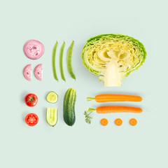 Creative layout made of cucumber, carrot, tomato, onion and cabbage and green beens. Flat lay. Food...