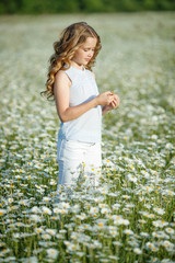 Fototapeta premium Little girl in a field with flowers 
