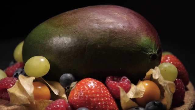 Fresh fruit mix on slowly rotating corc plate. Still high perspective close shot.