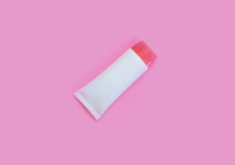 A tube of cream on a pink background. Skin care, moisturizing