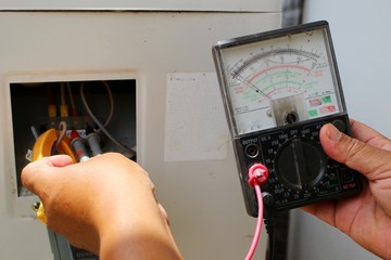 The technician is using tools to check the air conditioner, take a blur