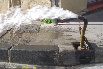 Picture of a water pipe flushing operation in the street. The water distribution network in large cities has become so old that it is necessary to constantly carry out repairs and pipes flushing.