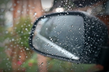 Rain drop on the window and a glass outside the car in the raining day. Selective focus. Transportation and nature concept.