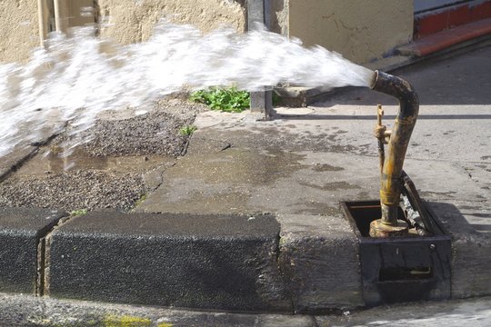 Picture Of A Water Pipe Flushing Operation In The Street. The Water Distribution Network In Large Cities Has Become So Old That It Is Necessary To Constantly Carry Out Repairs And Pipes Flushing.