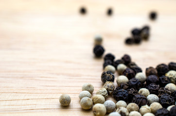 White-black pepper on a wooden plate
