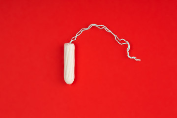 Medical female tampon on a pink background. Hygienic white tampon for women. Cotton swab. Menstruation, means of protection. Tampons on a red background. - obrazy, fototapety, plakaty