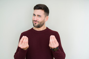 Young handsome man wearing a sweater over isolated background Doing money gesture with hand, asking for salary payment, millionaire business