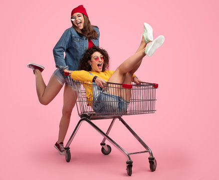Fotka „Cheerful young woman pushing shopping cart with friend“ ze služby  Stock | Adobe Stock