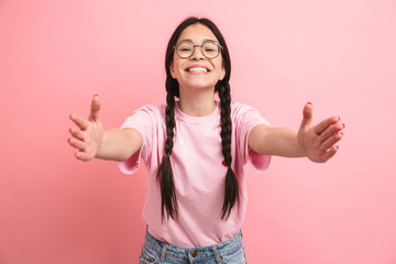 Image of cute european girl with two braids wearing eyeglasses smiling and reaching her arms forward at camera