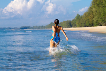 Woman with bikini blue sexy jump on wave at beach