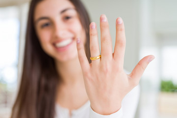 Beautiful young woman showing hand wearing wedding alliance ring