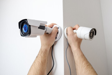 Workers installing video surveillance cameras on walls