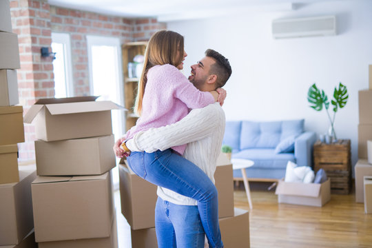 Young beautiful couple hugging in love celebrating very happy moving to new apartment