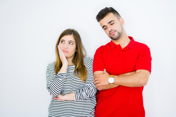 Young beautiful couple together over white isolated background thinking looking tired and bored with depression problems with crossed arms.