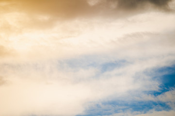 Fototapeta na wymiar Golden sunshine through the dark storm clouds with blue sky on background.