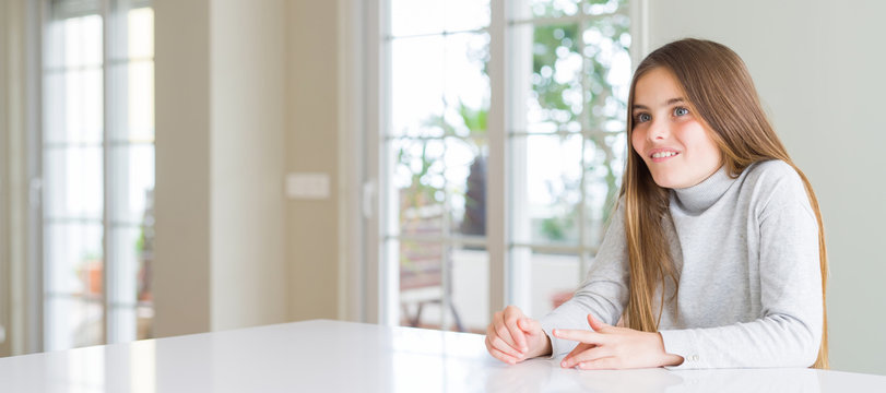 Wide angle picture of beautiful young girl kid wearing casual sweater making fish face with lips, crazy and comical gesture. Funny expression.