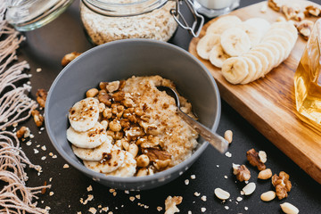 Healthy breakfast oatmeal bowl with banana and nuts
