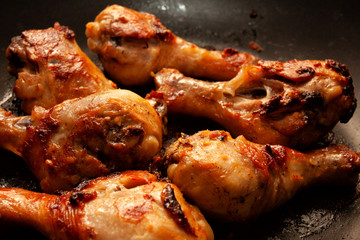 Roasted chicken legs in a black pan