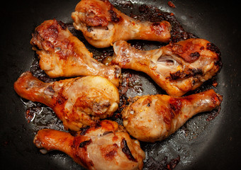 Roasted chicken legs in a black pan
