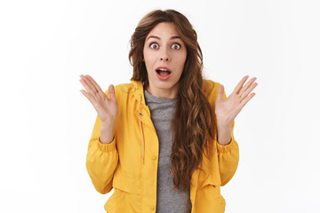 Surprised emotive wondered girl curly chestnut hairstyle drop jaw confused impressed raise hands up...